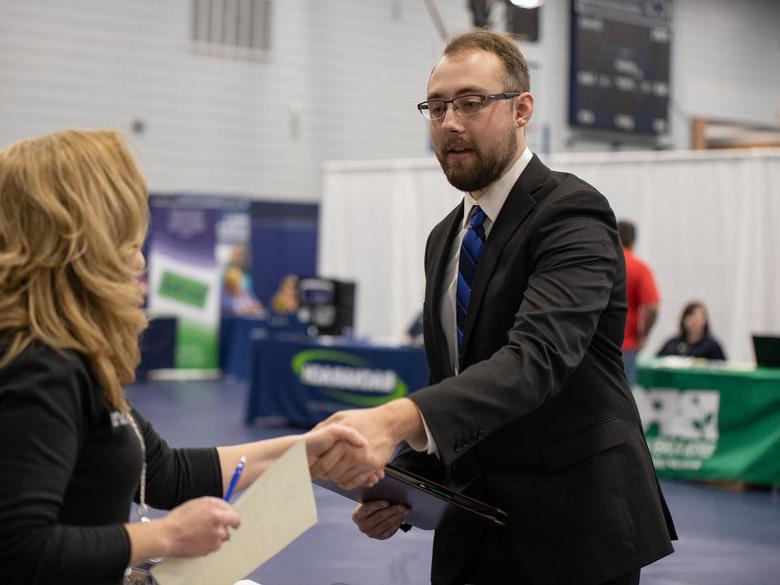 Various booths set up by companies in the gym during the annual Career Fair